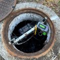 some wires and tech equipment sits inside a concrete-surrounded hole in the ground